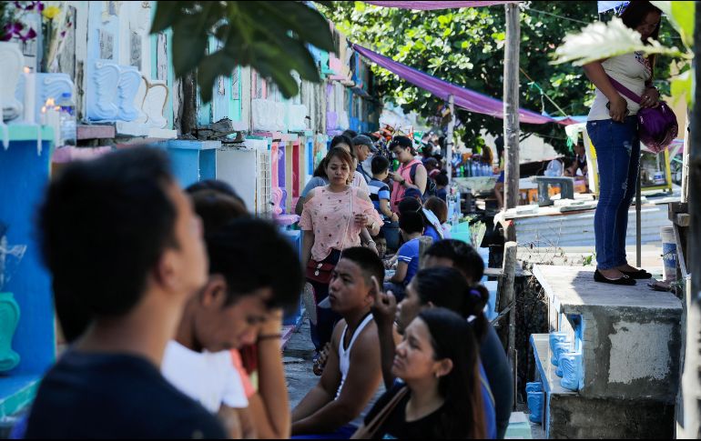 Comerciantes vendían flores, velas, comida, bebidas e incluso juguetes entre las tumbas recién lavadas a la multitud de familias que visitaban las sepulturas. EFE/M. Cristino
