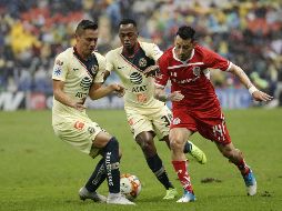 Los jugadores de América Paul Aguilar (i) y Alex Ibarra (c) disputan el balón con Rubens Sambueza (d) de Toluca. EFE/J. Méndez