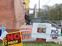 Unas personas entran a votar frente a carteles de candidatos a legislativas, a las afueras de la biblioteca pública Ruiz Branch en el sureste de Austin, Texas. EFE/J. Pascual
