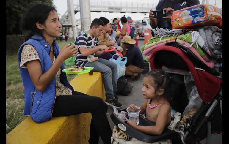 Apenas entraron a la ciudad, los viajantes recibieron agua y alimentos como gesto de solidaridad de la sociedad civil. Padre e hijo que viajan en la avanzada del grupo de migrantes cruzan un puente peatonal en el ingreso oriente de la ciudad. EL INFORMADOR / F. Atilano