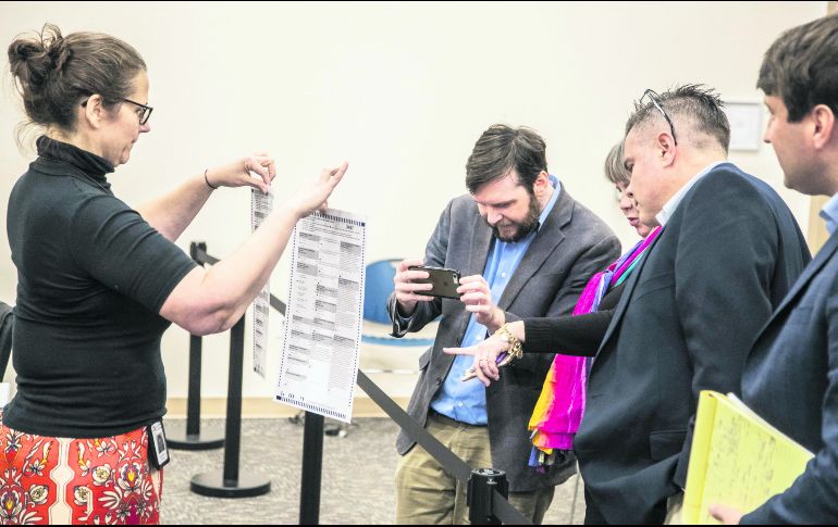 Funcionarios electorales muestran las actas de la elección en el condado de León. AFP