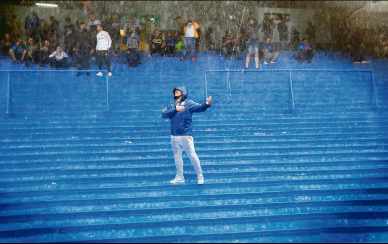 Pese a la fuerte tormenta, un seguidor de Boca no dejaba de entonar cánticos en apoyo a su equipo. EFE