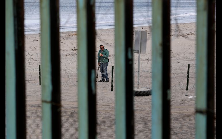 Un trabajador coloca una cerca de alambre de púas.