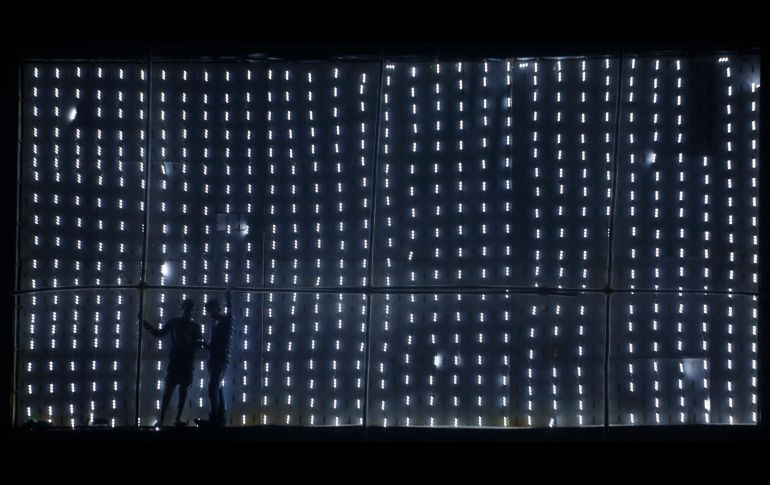 Trabajadores reparan un anuncio de luces en Ahmadabad, India. AP/A. Solanki