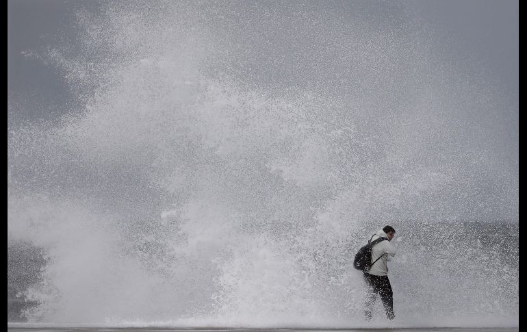 Un hombre desafía el fuerte oleaje en una playa de Barcelona, durante el temporal marítimo que ha obligado a activar la alerta naranja en la región española de Cataluña, en donde la llegada de una fuerte borrasca provoca olas de más de tres metros. EFE/ A. Dalmau