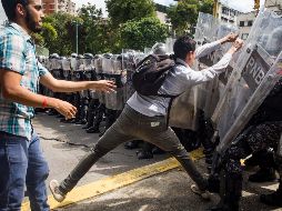 Estudiantes atacan a los policías que los mantienen cercados. Los agentes lanzaron gases lacrimógenos que afectaron a decenas de estudiantes. EFE/M. Gutiérrez