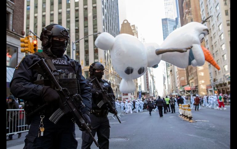 Policías armados vigilan el paso del desfile.