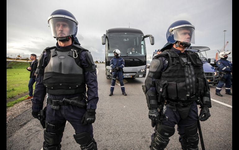 Agentes de policía escoltan un autobús con trabajadores de reemplazo para los estibadores que a se unen a una huelga en el puerto de Setúbal, Portugal. Los trabajadores portuarios que permanecen tienen contrato eventual y pretenden que la patronal establezca una contratación colectiva para 300 trabajadores temporales. EFE/ R. Minderico