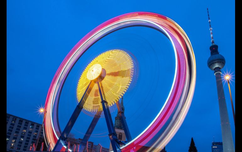 Una rueda de la fortuna gira junto a la Torre de telecomunicaciones en Berlín, Alemania. EFE/ O. Messinger