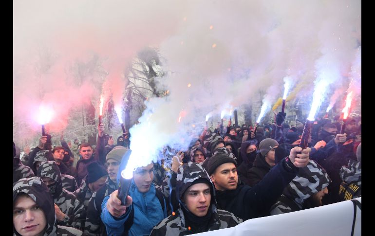 Activistas ucranianos de ultraderecha queman bengalas durante una manifestación frente al Parlamento en Kiev, Ucrania. El presidente ucraniano, Petró Poroshenko, firmó hoy un decreto en el que declara el estado de excepción en el país tras el apresamiento este domingo de tres buques de la Armada ucraniana por parte de los guardacostas rusos en el mar Negro cerca de Crimea. AFP/S. Supinsky