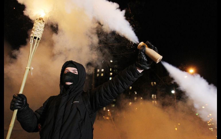 Activistas ucranianos sostienen antorchas y gritan consignas durante una concentración para conmemorar el quinto aniversario de la revolución del 