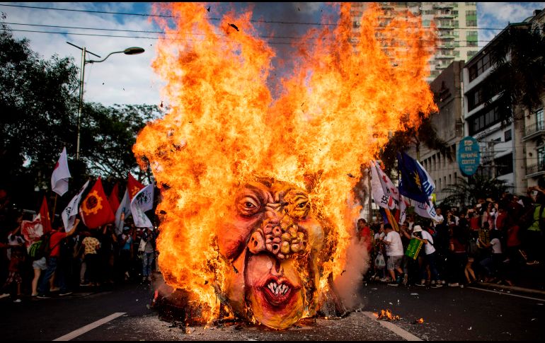 Activistas queman una figura del presidente filipino Rodrigo Duterte cerca de la Embajada estadounidense en Manila, en el marco de la conmemoración del natalicio 155 del héroe Andrés Bonifacio. AFP/N. Celis