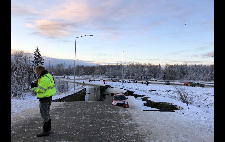 Un gran tramo de una carretera cercana al aeropuerto de la ciudad se desplomó, dejando varado a un automóvil en una estrecha isla de pavimento.
