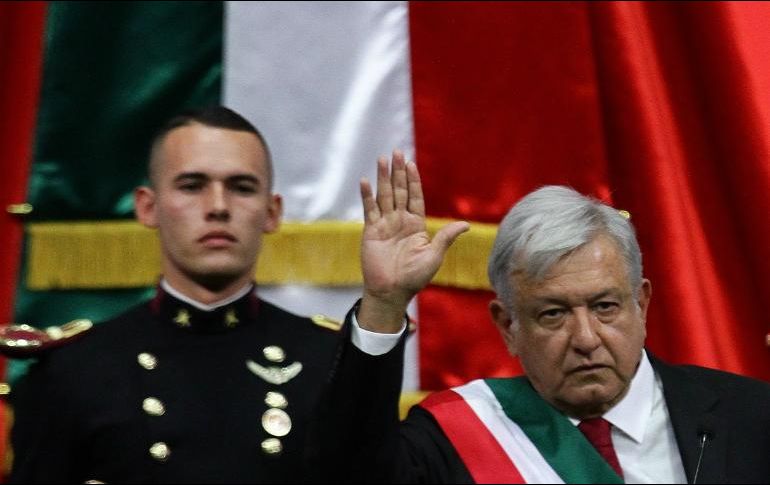 El cadete ayuda a López Obrador a colocarse la banda presidencial. NTX / A. Monroy