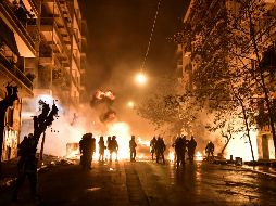 Jóvenes lanzaron bombas molotov a los elementos de seguridad. AFP/A. Messinis