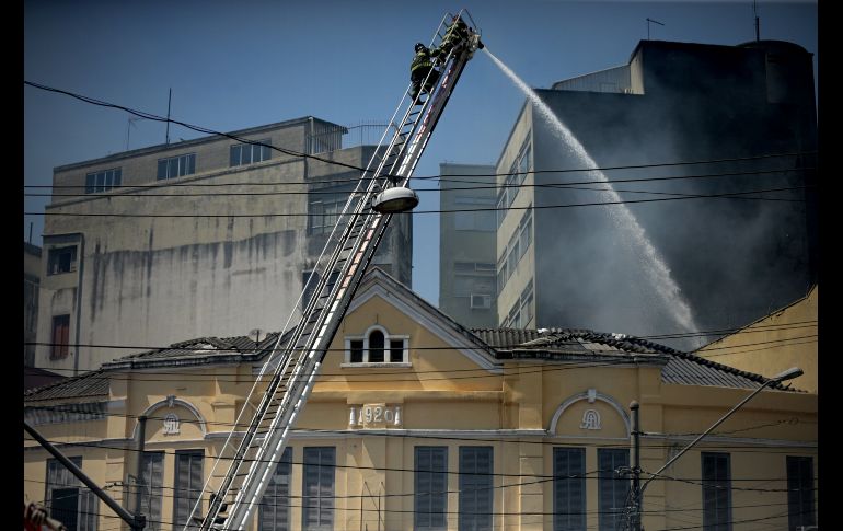 Bomberos controlan un incendio registrado en una céntrica calle y uno de los principales puntos de compras navideñas de Sao Paulo, Brasil. EFE/F. Bizer