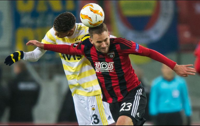Diego Reyes (de amarillo) pelea por alto con Marek Bakos del Spartak Trnava, en el duelo donde Fenerbahce perdió, aunque ya estaba clasificado. AFP/V. Simicek