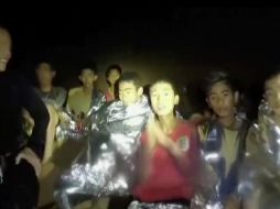 Niños del grupo de 12 integrantes de un equipo de futbol y su entrenador se ven dentro de una cueva en Mae Sai, Tailandia, junto a marinos que los acompañan mientras se hallaba la mejor forma de sacarlos. AP/Thai Navy Sea/ARCHIVO