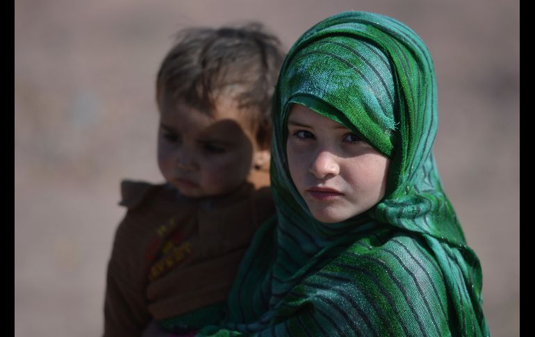 Una afgana carga a su hermano en un campamento de refugiados a las afueras de Islamabad, Pakistán, el 1 de febrero. Cerca de 1.4 millones de afganos se encuentran como refugiados en este país. AFP/A. Qureshi