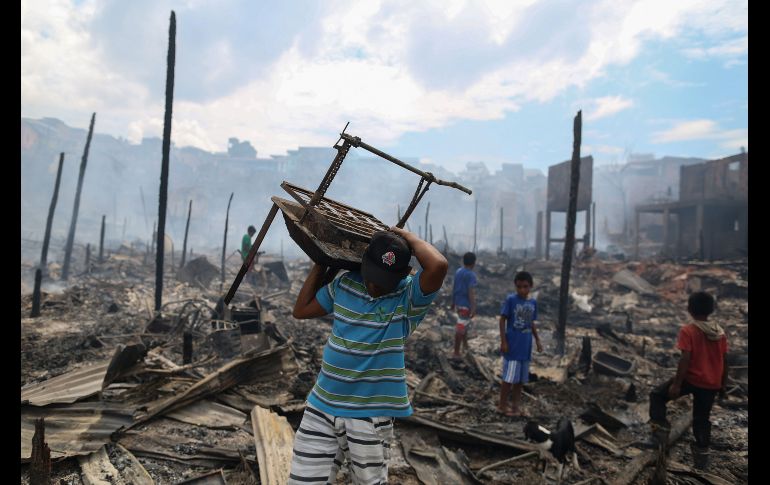 Vecinos intentaban recuperar objetos tras el incendio.
