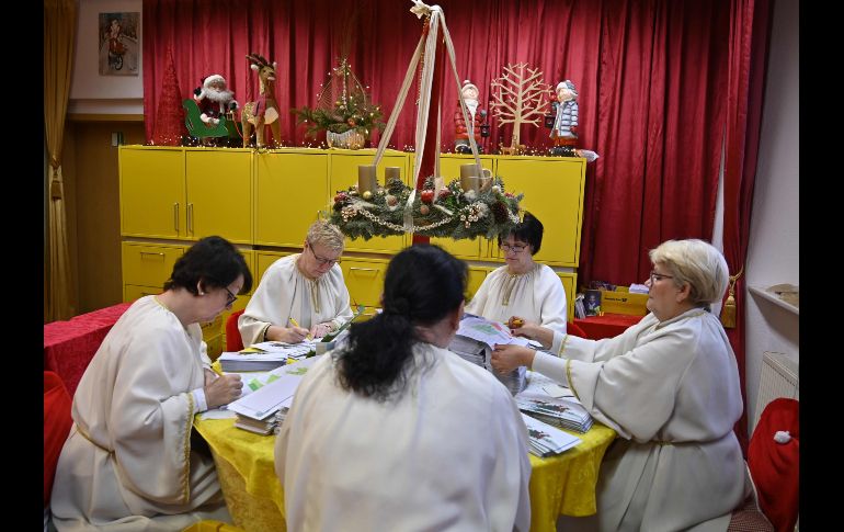 Mujeres vestidas como ayudantes de Santa Claus responden cartas de Navidad de niños en el centro postal de Himmelpfort, Alemania. AFP/T. Schwarz