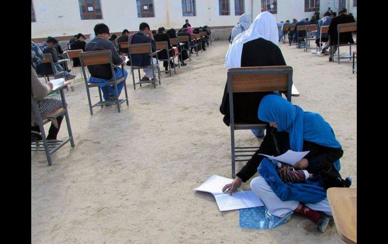 Jahantab Ahmadi, de 25 años, realiza un examen de ingreso a la universidad con su bebé en los brazos en Daikundi, Afganistán, el 16 de marzo. La imagen se volvió viral tras ser compartida en redes sociales, lo cual llevó a que le ofrecieran un lugar en la universidad de Kabul y apoyo para su estancia. ESPECIAL/Khaliq Ahmadi
