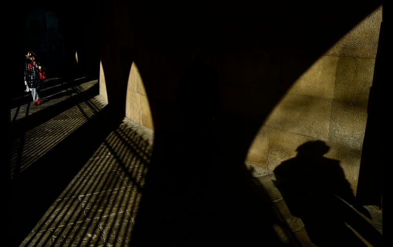 Una mujer camina por el antiguo porche del templo de San Nicolás en Pamplona, España. AP/A. Barrientos El presidente ruso Vladimir Putin llega a su conferencia de noticias anual en Moscú. AP/A. Zemlianichenko