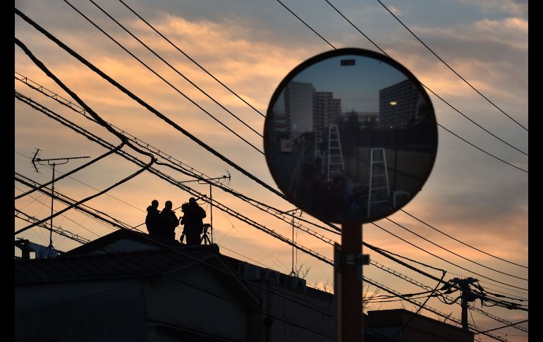 Un equipo de una televisora aguarda en un techo para captar la salida de Carlos Ghosn, ex director de Nissan, del centro de detención en Tokio, Japón. Un tribunal japonés rechazó hoy la solicitud para extender la detención de Ghosn, que enfrenta cargos de no reportar todos sus ingresos. AFP/K. Nogi