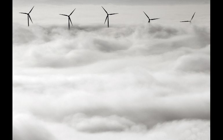 Las palas de varios aerogeneradores emergen entre la niebla que cubre la comarca de Pamplona, España, en una jornada en la que este fenómeno meteorológico es la nota predominante en la región de Navarra. EFE/J. Diges