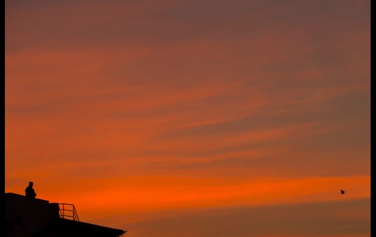 Un hombre en el techo de una casa observa la puesta de sol en Katmandú, Nepal. EFE/H. Shrestha
