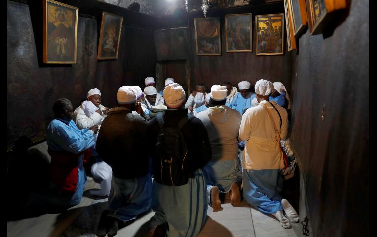 Peregrinos cristianos rezan en la Gruta de la Iglesia de la Natividad en la ciudad cisjordana de Belén, antes de la procesión anual de Nochebuena. EFE/A. Safadi