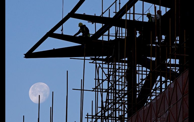 Trabajadores cargan cables en un centro comercial en renovación en Pekín, China. AP/A. Wong