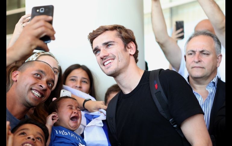 El futbolista francés del Atlético de Madrid Antoine Griezmann (c) atiende a aficionados a su llegada a Montevideo,  Uruguay. El futbolista francés está de visita para asistir a la boda de su compañero uruguayo Diego Godín. EFE/F. Anfitti