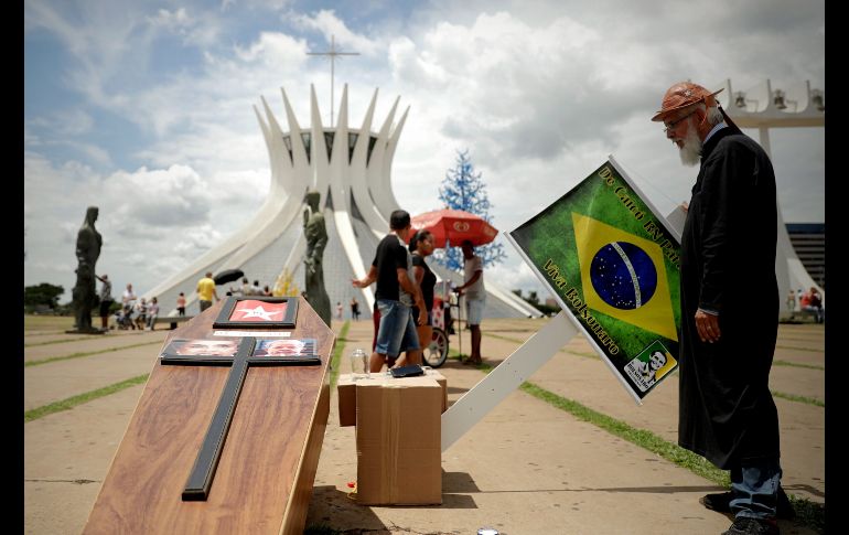 Un seguidor del presidente electo de Brasil, Jair Bolsonaro, coloca un ataúd con las fotografías de los expresidentes brasileños Dilma Rousseff y Luiz Inácio Lula da Silva en la Explanada de los Ministerios, en Brasilia. El ultraderechista Bolsonaro será investido presidente el 1 de enero. EFE/F. Bizerra Jr