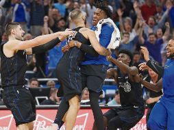 Evan Fournier (centro) es felicitado por sus compañeros después de conseguir la canasta del triunfo para Orlando. AP