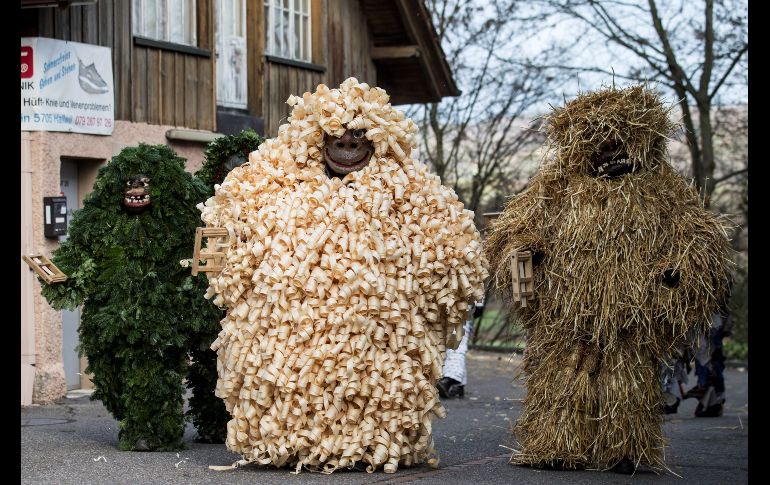 Varias personas caminan por una calle disfrazadas del tradicional 