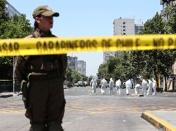 Personal antibombas inspecciona los restos dejados por el estallido y habría realizado una explosión ''preventiva'' de una caja sospechosa que encontraron cerca de la parada. EFE / A. Valdés