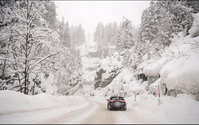 A lo largo de las carreteras, varios vehículos atrapados entre la nieve se alcanzaban a vislumbrar como parte del paisaje. EFE/C. Bruna