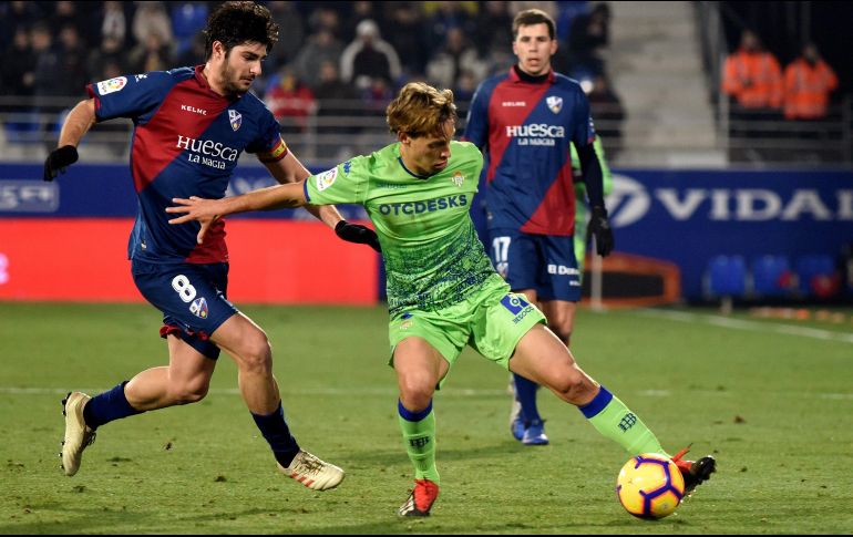 El centrocampista del Huesca, Gonzalo Melero (i), lucha por el balón ante el centrocampista del Real Betis, Sergio Canales (c), durante el partido. EFE/J. Blasco