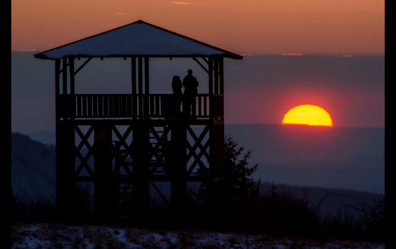 Dos personas observan el atardecer desde una colina en Salgotarjan, Hungría. EFE/P. Komka