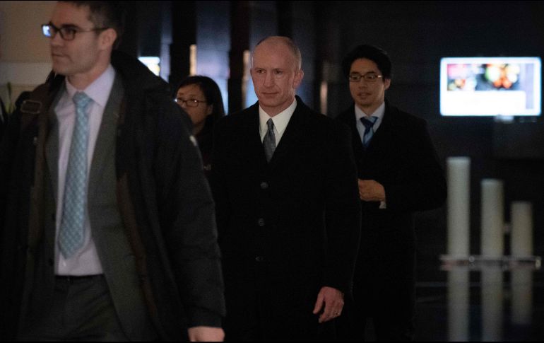 Jeffrey Gerrish (centro), representante comerical de EU, y otros miembros de la comitiva salen del hotel donde negocian con sus pares chinos. AFP/W. Zhao