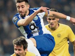 Héctor Herrera (centro) disputa un balón con Alecs Palocevic ,del Nacional. EFE