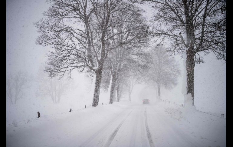 Un vehículo transita en Warngau, en el sur de Alemania. Fuertes tormentas invernales azotan Europa esta semana.