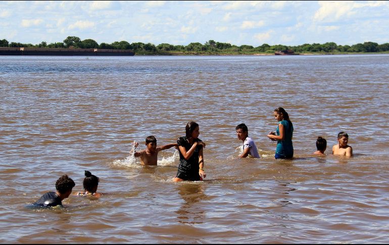 En los alrededores hay familias enteras, y sobre todo jóvenes, que se bañan por 