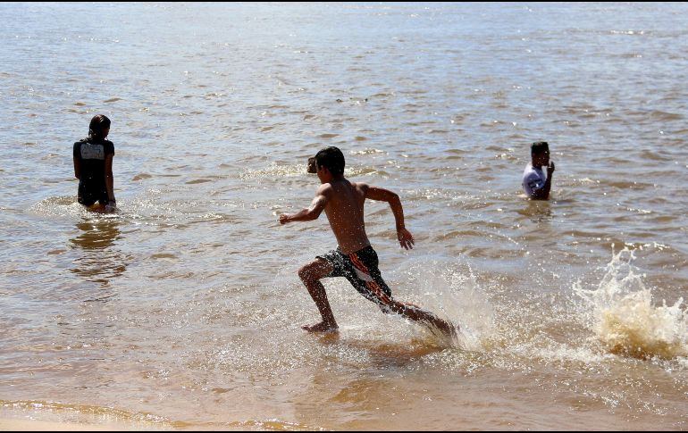 En los alrededores hay familias enteras, y sobre todo jóvenes, que se bañan por 