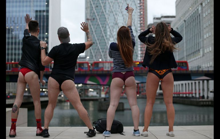 Jóvenes posan para una foto cerca de la estación de metro en Canada Wharf en Londres, Inglaterra.