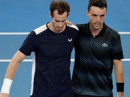 Murray, cojeante, se apoya en Roberto Bautista para salir de la cancha. AP