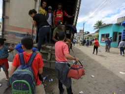 Migrantes hondureños bajan de un camión que los acercó al municipio de Cucuyagua. EFE/G. Amador