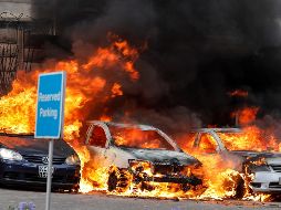 Varios coches arden en un estacionamiento cerca de donde se produjeron un tiroteo y varias explosiones, en un complejo hotelero de Nairobi. EFE/D. Kurokawa