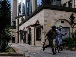 Soldado ayuda a escapar a una ocupante del hotel DusitD2. Más de 700 civiles fueron evacuados del complejo desde el comienzo del ataque. AFP/K. Dhanji